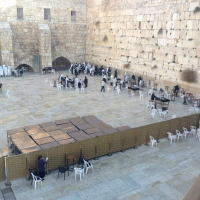 The holiest place in Judaism, notice the male section of the Western Wall on the left-hand side and the women praying area on the right, a fence (a wall) separate their differences but not their prayers