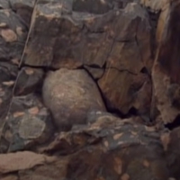 An erratic granite bolder dated 2.4 billion year stuck in rocks in Canada